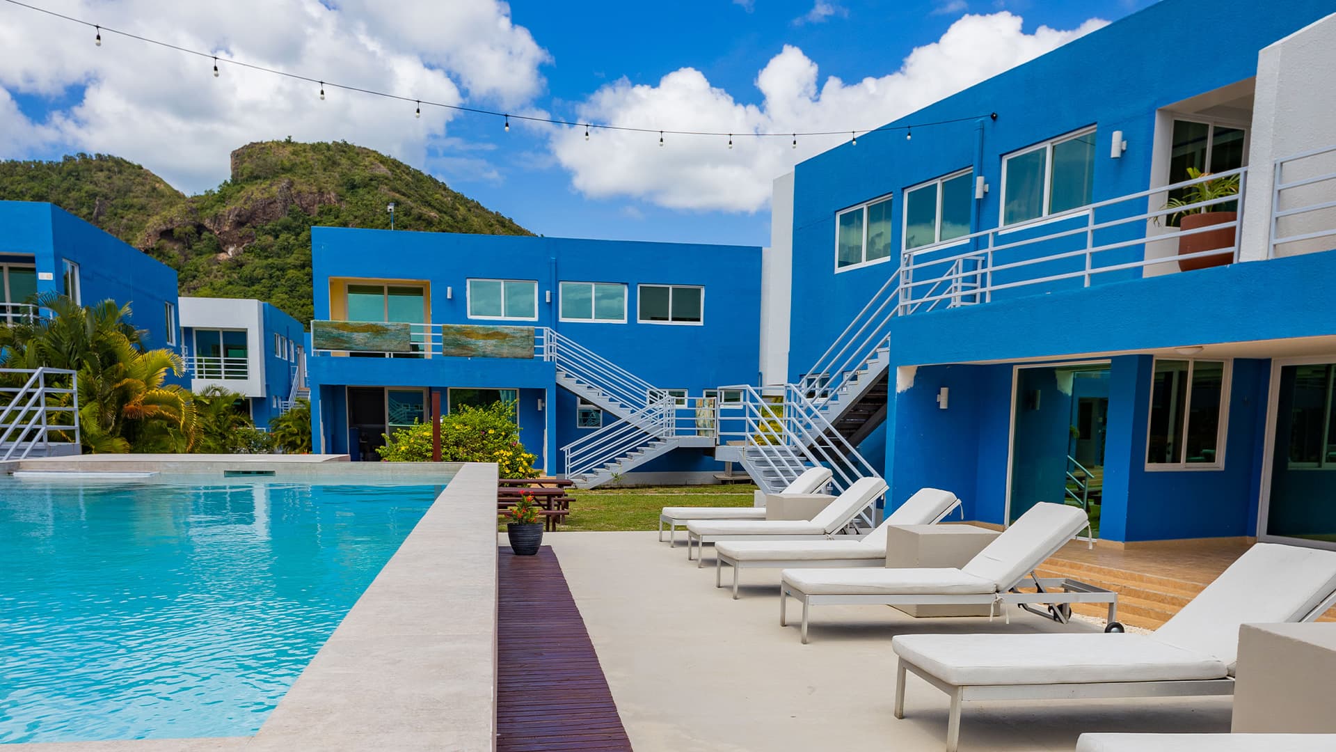 Pool at Harbour Island Residences with white lounge chairs and blue buildings in the background